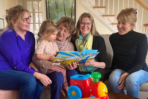 The Dolly Parton Library is coming to Antigonish. Here, Betty Rose Landry, left, Jan VanGestel, Kathleen Robertsson and Jayne Chisholm share a book with VanGestel's granddaughter, Etta Simms. - Contributed