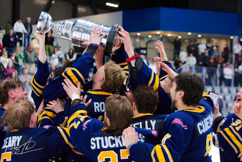 Yarmouth Mariners players reach out to touch the MHL Metalfab Cup as the team celebrated their league championship win after a Game 4, 5-1 win over the Edmundston Blizzard on April 21. PERCY PICARD PHOTO