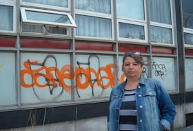 CBRM councillor Earlene MacMullin stands outside the former North Sydney Post Office building, which has fallen into disrepair and filled with graffiti, broken windows and biohazard signs warning of asbestos inside the building. IAN NATHANSON/CAPE BRETON POST