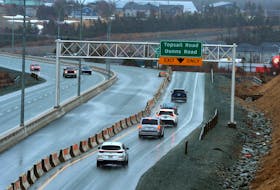 Vehicles exit and enter the Team Gushue Highway at Topsail Road Tuesday as the unfinished section of roadbed sits in the background. Keith Gosse • The Telegram
