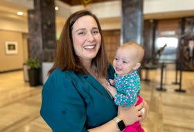 Erin Cullen with her daughter, Aoife, at the Confederation Building lobby on Thursday, May 11. Cullen says Aoife has been on daycare waitlists since she was born, and she’s 11 months old now. She says she has “no hope” of finding a space. -Juanita Mercer/SaltWire Network