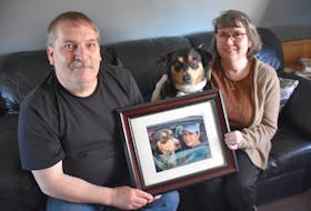Peter and Sharon Stewart, of Yarmouth, sit with their daughter Jocelyn's dog Amani, holding a photograph of Jocelyn and Amani in their life together. Jocelyn died by suicide years ago at the age of 18. Her parents hope to help others in her memory. TINA COMEAU PHOTO