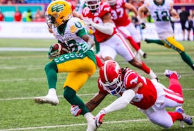 Calgary Stampeders defensive back Michael Griffin reaches out to grab Edmonton Elks wide receiver C.J. Sims at McMahon Stadium in Calgary on Monday, May 22, 2023.