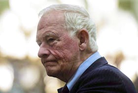 A reporter looks over David Johnston's first report on foreign interference on May 23, 2023. Johnston recommended that public hearings be held on the issue, rather than a public inquiry.