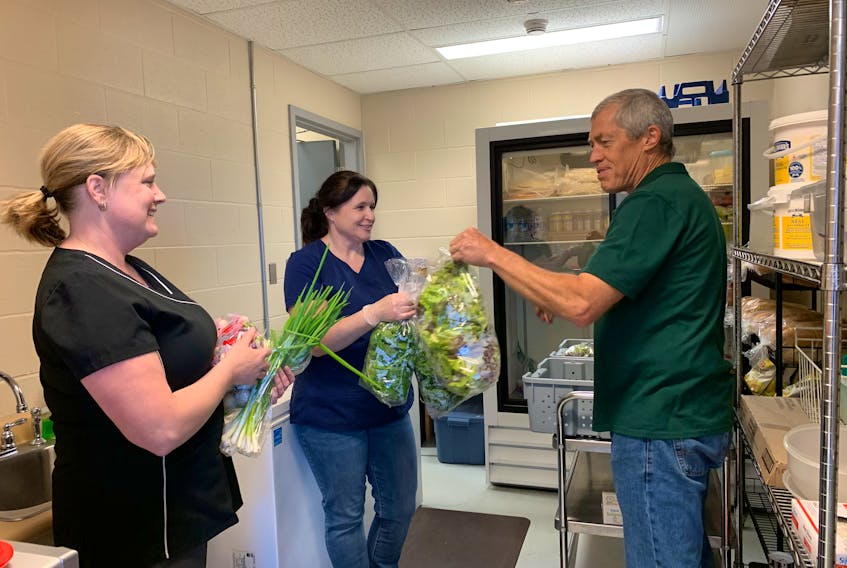 Tracy Nickerson (from left) cafeteria supervisor at BMHS  and cafeteria sub bar specialist Denise Smith accept delivery of fresh organic produce from Matthew Roy, owner of Coastal Grove Farm in Port LaTour. The pilot project is a Health Promoting Schools (HPS) initiative. KATHY JOHNSON