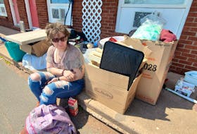Sarah Kowalski sits on the curb with her belongings on the afternoon of Tuesday May 23. Kowalski and a handful of other tenants have been evicted from the Summerside Motel, which is currently contracted by the province to temporarily house Islanders in need of emergency shelter. Colin MacLean