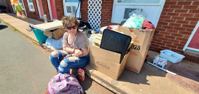 Sarah Kowalski sits on the curb with her belongings on the afternoon of Tuesday May 23. Kowalski and a handful of other tenants have been evicted from the Summerside Motel, which is currently contracted by the province to temporarily house Islanders in need of emergency shelter. Colin MacLean