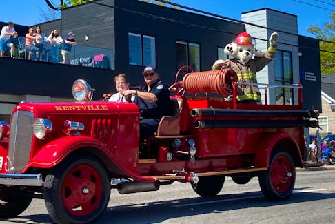 Sparky the Fire Dog waves from the back of an antique fire truck during the Annapolis Valley Apple Blossom Festival children's parade Saturday morning in Kentville.