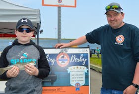Port Morien Wildlife Association president Jeff McNeil chats with Dylan Gillis, 11, of New Waterford about his rainbow trout catch at the annual fishing derby for kids and youth at the Beacon Street Dam in Glace Bay.
BARB SWEET/CAPE BRETON POST