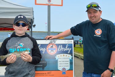 Port Morien Wildlife Association president Jeff McNeil chats with Dylan Gillis, 11, of New Waterford about his rainbow trout catch at the annual fishing derby for kids and youth at the Beacon Street Dam in Glace Bay.
BARB SWEET/CAPE BRETON POST