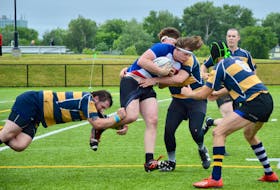 In this file photo, Kelland Griffin of the Caledonia Rugby Club, middle, runs into a wall of Riverlake Ramblers while attempting to advance the ball upfield during Nova Scotia Division 2 Rugby League action at Open Hearth Turf Field in Sydney in 2021. For the second straight year, Caledonia won’t field a team in provincial play. CAPE BRETON POST PHOTO