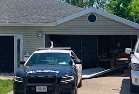 A broken garage door litters the driveway of a Stoney Creek home on Monday, May 29, 2023, where two people were slain and their alleged killer was shot to death by police over the weekend. 