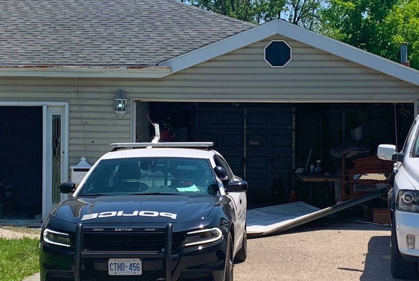 A broken garage door litters the driveway of a Stoney Creek home on Monday, May 29, 2023, where two people were slain and their alleged killer was shot to death by police over the weekend. 