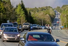 RCMP officers direct a long lime of traffic as resiidents from nearby subdivisions evaciaute an Uppr Tantallon area wildfore, on Hammonds Plains Road in Upper Tantallon Sunday May 28, 2023.


TIM KROCHAK PHOTO
