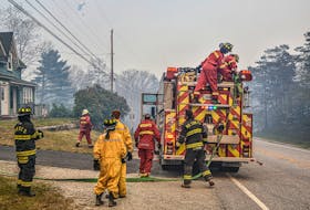 Firefighters make one of many stops on May 29 to check on properties in Shelburne County where a wildfire continues to burn, impacting many communities and forcing evacuations. FRANKIE CROWELL