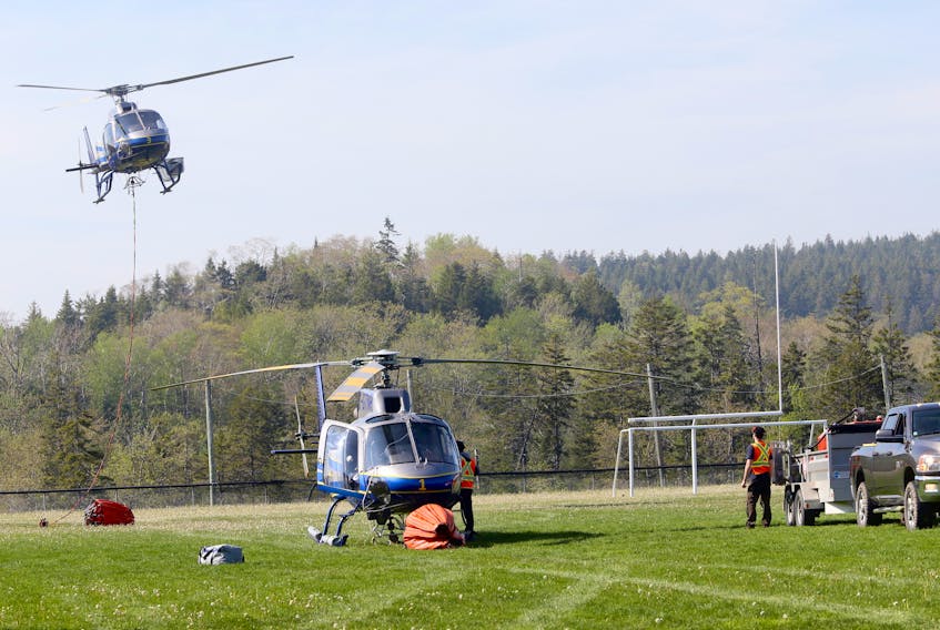 A Natural resources helicopter is refueled  as another lifts off in the ballfield at Bayview high school, during wildfire assistance in Upper Tantallon May 30, 2023


TIM KROCHAK PHOTO