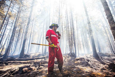 A Nova Scotia firefighter radios in while working in the area of the Tantallon wildfire.