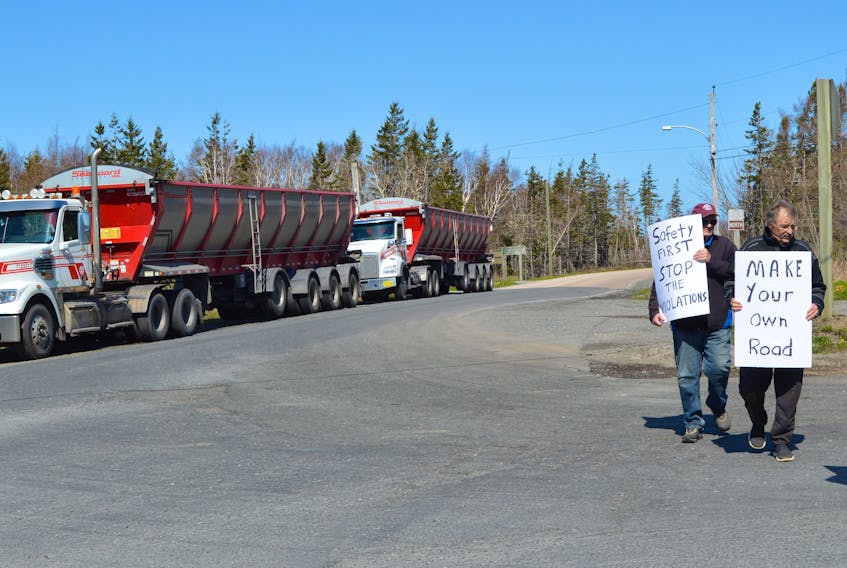 Two transport trucks sit idling as protesters stage a rally blocking the entrance of Long Beach Road in Port Morien on Tuesday morning. IAN NATHANSON/CAPE BRETON POST