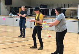 Asa Nodelman (centre) helping Elisa Rudolph master the devil sticks during a recent Circus FACTory at the NSCC session. Richard MacKenzie