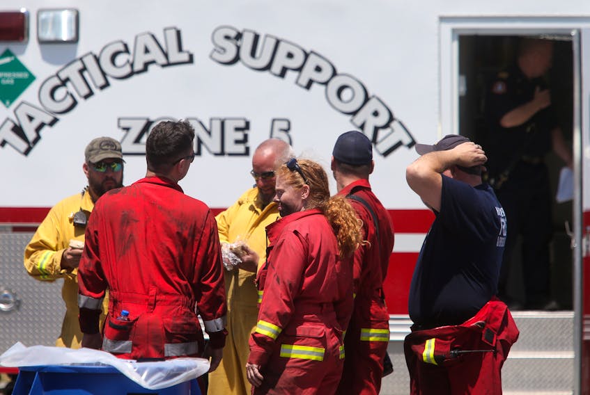 Firefighters confer while grabbing sandwiches and watering up, during a break for lunch from firefighting, at the wildfire command centre in Upper Tantallon Wednesday May 31, 2023.

TIM KROCHAK PHOTO