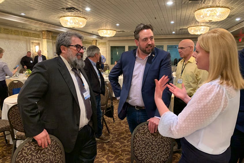 At a business conference in Marystown the last week in April, industry minister Andrew Parsons (centre) chatted with Jim Stump of Braya, the company that owns the refinery at Come By Chance, and Heidi Kirby of ABO, the company that wants to build a wind farm to produce hydrogen for the refinery.