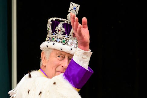 King Charles III waves from the balcony of Buckingham Palace following his and Queen Camilla's coronation on May 6, 2023 in London, England. - Leon Neal / Pool via Reuters