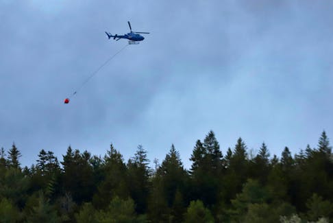 A Natural Resources Department helicopter with a water bucket battles a wildfire in the Upper Tantallon area on Sunday, May 28, 2023. TIM KROCHAK - THE CHRONICLE HERALD