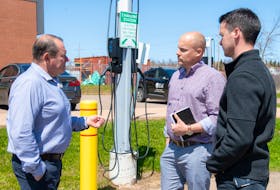 Fred Horrelt, associate vice-president facilities management and construction at UPEI, discusses the new electric vehicle chargers with Ross Dwyer, manager of research partnerships at the Canadian Centre for Climate Change and Adaptation and Nathan MacLeod, manager of capital projects and planning at UPEI. - Contributed