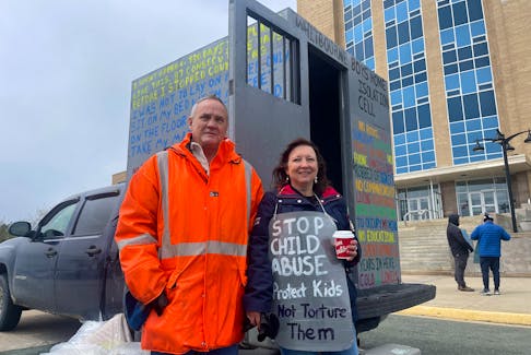 Jack Whalen and his wife, Glennis Whalen, stand outside the replica isolation cell Jack built and brought to Confederation Building in St. John's, Monday, June 12. TARA BRADBURY • THE TELEGRAM