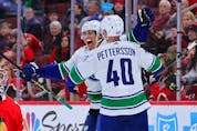  Ethan Bear #74 and Elias Pettersson #40 of the Vancouver Canucks celebrate a goal against the Chicago Blackhawks during the third period at United Center on March 26, 2023 in Chicago, Illinois.