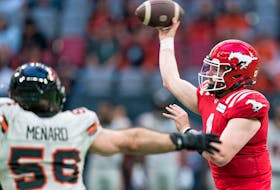 Calgary Stampeders quarterback Logan Bonner throws a pass while being pressured by B.C. Lions defensive lineman David Menard during pre-season action at BC Place in Vancouver on Thursday, June 1, 2023.