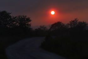 The smoke from the Barrington wildfire, works as a filter to the setting sun, seen at a winding road near Lockport, NS Thursday evening June 1, 2023.

TIM KROCHAK PHOTO
