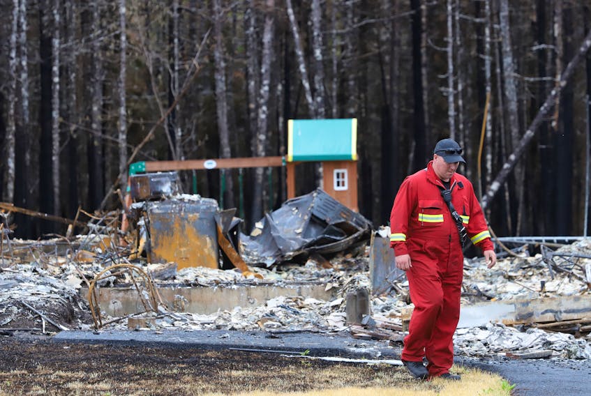 Halifax regional firefighter, Adrian Sweet walks between the intact playset and a destroyed home on Bonsai Drive following last week's wildfire in Hammonds Plains, NS Tuesday June 6, 2023. 
POOL/Haifax Chronicle Herald-Tim Krochak