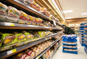  A worker restocks shelves in the bakery and bread aisle at a grocery store in Halifax. Canada Bread has settled allegations it took part in a price-fixing scheme that regulators contend began in 2001 and spanned at least 14 years.