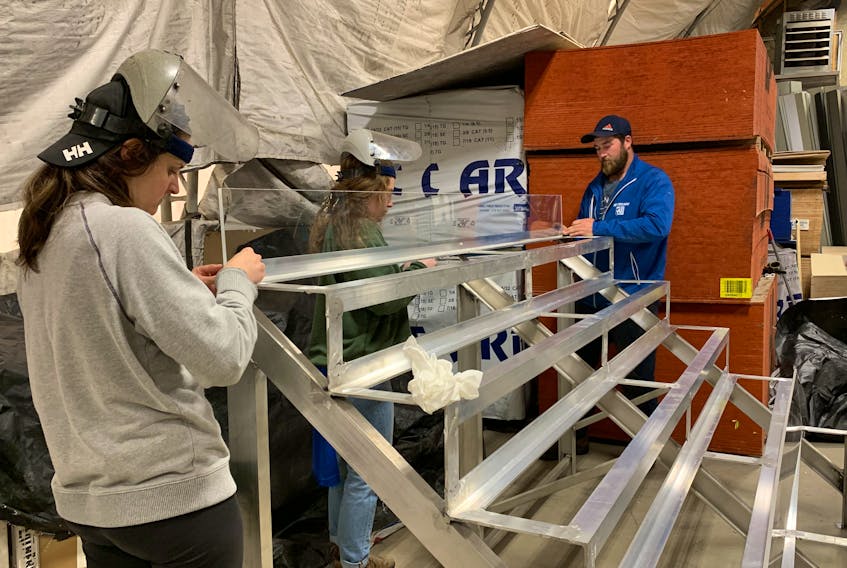 Volunteers Leah Swaine (from left) Emily LeBlanc and Joey MacDonnell work on constructing the five tier aluminum lobster racing track at MSJ Building Supplies in Barrington Passage. KATHY JOHNSON