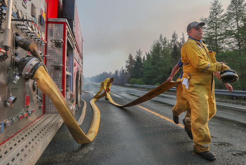 Northfield Fire Department members haul line to spray down a Shelburne County wildfire flareup along Highway 103 on Friday, June 2. COMMUNICATIONS NOVA SCOTIA
