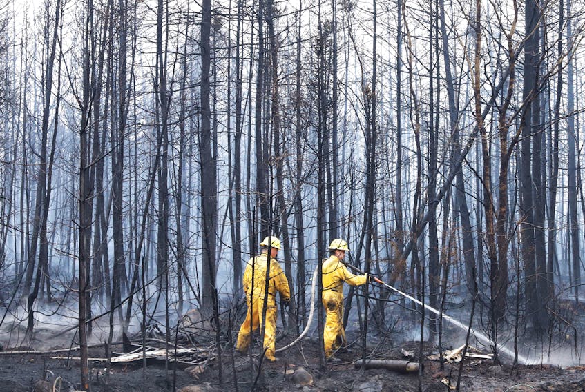 Annapolis Royal firefighters Jason Rock, left, and Anthony Lopiandowski spray hot spots in the Birchtown area, Shelburne County, on Saturday morning, June 3. COMMUNICATIONS NOVA SCOTIA
