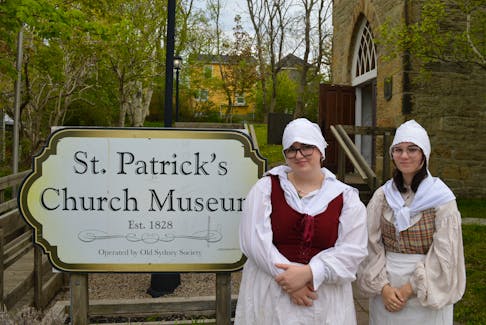 Historic interpreters Ainsley Maclean, left, and Faith MacNeil stand outside St. Patrick's Church Museum on the Esplanade, one of four museums the Old Sydney Society operates. EMILY CONOHAN/CAPE BRETON POST