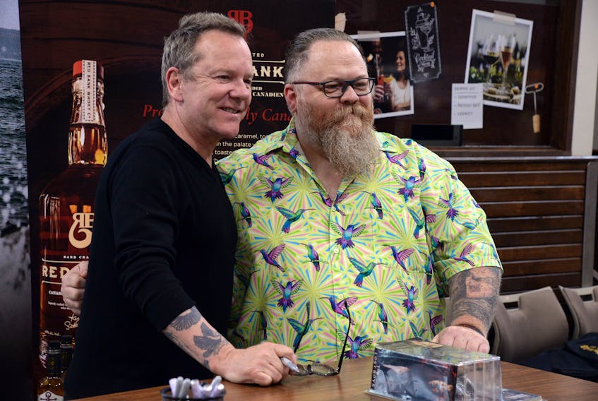 Warren Brophy of St. John’s poses for a photo with actor Kiefer Sutherland during a promotional signing of bottles of his Red Bank Whisky in St. John’s Monday afternoon. Brophy has a tattoo of Sutherland’s character from the movie “The Lost Boys” on his left forearm. Keith Gosse • The Telegram