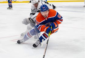 Kailer Yamamoto (56) of the Edmonton Oilers, skates into the corner with Quinton Byfield of the Los Angles Kings at Rogers Place in Edmonton on March 30, 2023.  Photo by Shaughn Butts-Postmedia