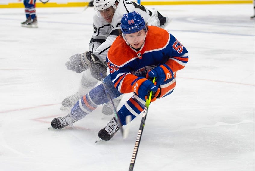 Kailer Yamamoto (56) of the Edmonton Oilers, skates into the corner with Quinton Byfield of the Los Angles Kings at Rogers Place in Edmonton on March 30, 2023.  Photo by Shaughn Butts-Postmedia