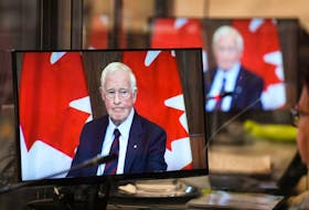 Special Rapporteur David Johnston is seen on the screens of translators as he presents his first report about foreign interference in Canadian elections and government, on May 23, 2023.