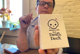 Nancymarie Arsenault, Hospice P.E.I.’s executive director, holds up one of the death decks she bought to help lead conversation at the death cafe. – Kristin Gardiner/SaltWire