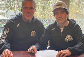 Charlottetown Islanders general manager and head coach Jim Hulton, left, joins centre Matthew Butler as he signs with the Quebec Major Junior Hockey League team for the 2023-24 season. The Islanders drafted Butler, who is from St. John’s, in the fifth round of the league's 2022 entry draft. Contributed