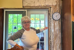 Kathy Walsh points to the new insulation that a contractor installed back in November. Due to damage from Fiona, water had penetrated all the way from the roof down through the walls to her basement. Thinh Nguyen • The Guardian