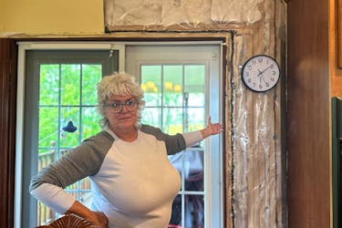 Kathy Walsh points to the new insulation that a contractor installed back in November. Due to damage from Fiona, water had penetrated all the way from the roof down through the walls to her basement. Thinh Nguyen • The Guardian