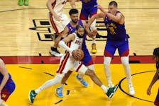 Caleb Martin #16 of the Miami Heat drives to the basket against Jamal Murray #27 and Nikola Jokic #15 of the Denver Nuggets during the first half in Game Three of the 2023 NBA Finals at Kaseya Center on June 07, 2023 in Miami.  