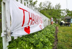 A thank you sign at the Barrington Passage home of Roberta Hopkins, who is gardening in the background. COMMUNICATIONS NOVA SCOTIA