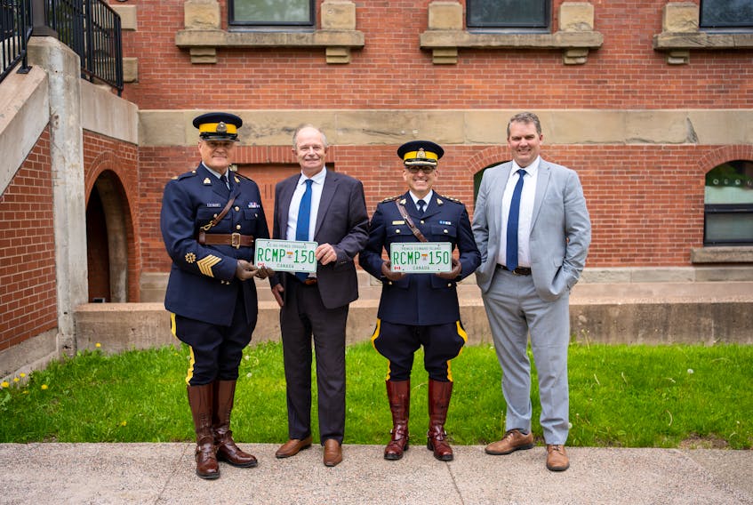 Troy MacLean, acting Sgt. Maj. of the RCMP L Division, left, Transportation and Infrastructure Minister Ernie Hudson, RCMP Chief Superintendent Derek Santosuosso and Justice and Public Safety Minister Bloyce Thompson displaying new RCMP 150 commemorative license plates. Contributed