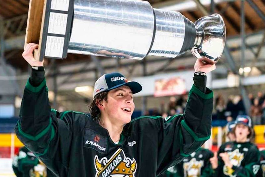 Saint-Hyacinthe Gaulois centre Caleb Desnoyers raises the Quebec under-18 hockey league championship trophy earlier this year. - Hockey Canada